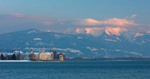 a castle in the middle of the water with mountains at Ferienwohnungen Spiegel Felsgässele in Lindau