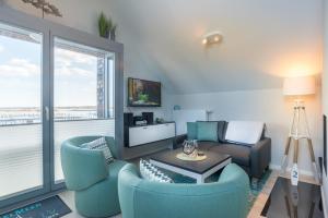 a living room with blue chairs and a couch at Ostsee - Appartement Nr 30 ''Küstenkieker'' im Strand Resort in Heiligenhafen
