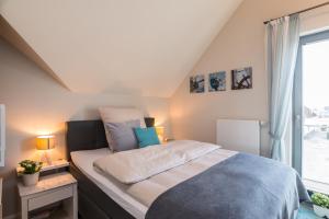 ハイリゲンハーフェンにあるOstsee - Appartement Nr 30 ''Küstenkieker'' im Strand Resortのベッドルーム1室(大型ベッド1台、窓付)