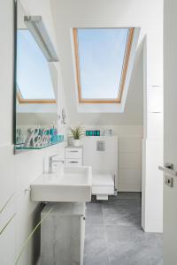a white bathroom with a sink and a mirror at Ostsee - Appartement Nr 30 ''Küstenkieker'' im Strand Resort in Heiligenhafen