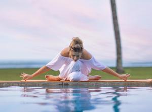 a woman in a white dress sitting on the edge of a pool at Heritance Ayurveda - All Meals and Treatments in Bentota