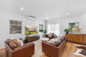 a living room with two couches and a table at La Mer in Marcoola in Marcoola