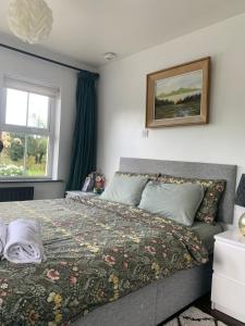 Un dormitorio con una cama con una manta. en Isserkelly House, en Clonbur
