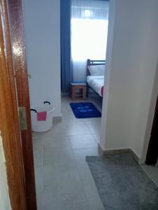 einen Flur mit einem Zimmer mit einem Bett und einem Fenster in der Unterkunft Amalya suites . in Eldoret