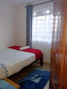 ein kleines Schlafzimmer mit einem Bett und einem Fenster in der Unterkunft Amalya suites . in Eldoret