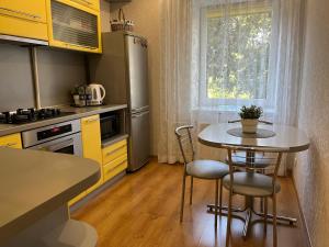 a small kitchen with a table and chairs in it at Center two bedroom apartment in Daugavpils