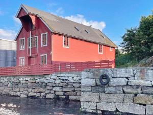 a red house sitting on top of a stone wall at 12 person holiday home in Selje-By Traum in Selje