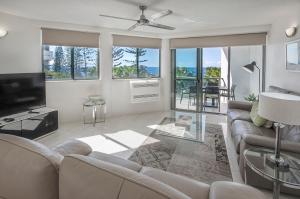a living room with a couch and a tv at Malibu Apartments in Mooloolaba