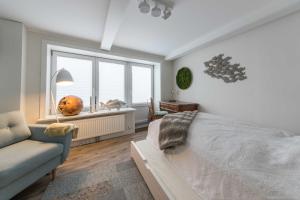 een slaapkamer met een bed, een bank en een raam bij Exklusives Nordic Lighthouse in Bredstedt