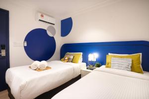 two beds in a room with blue and white at Ukiyo Hotel in Petaling Jaya