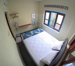 Cama grande en habitación con ventana en Sendangarum Village Guest House Jogja, 