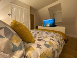 a bedroom with a bed and a television on a wall at The Cotswold Stowaway, Perfect Luxurious Retreat! in Stow on the Wold
