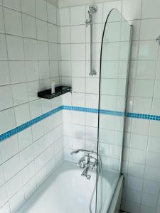 a bathroom with a shower with a tub and a sink at Barnes the village in the centre of London in London