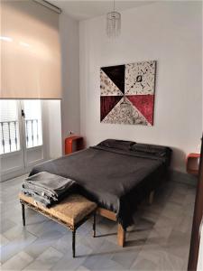 a bedroom with a bed and a painting on the wall at Apartamento Santa Cruz Casco Antiguo con Terraza in Seville