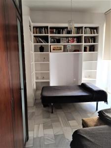 a room with a bench in front of a book shelf at Apartamento Santa Cruz Casco Antiguo con Terraza in Seville