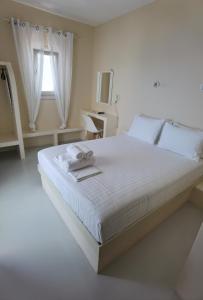 a bedroom with a large white bed with a window at Villa Panorama in Irakleia