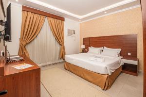 a hotel room with a large bed and a desk at فندق غالية احد in Al Madinah