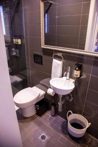 bagno con servizi igienici, lavandino e specchio di Bayswater Boutique Lodge a Sydney