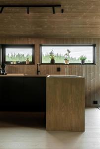a kitchen with a counter and two windows at Moderne hytte på Norefjell in Noresund