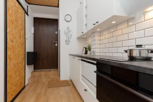 a kitchen with white walls and a wooden door at Sweet Studio Wola for 2 Guests with Loft Bed in Warsaw