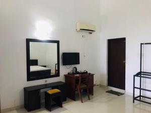 a room with a mirror and a desk with a bed at Hambantota Rest House in Hambantota