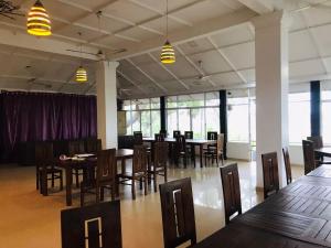 a dining room with tables and chairs and windows at Hambantota Rest House in Hambantota