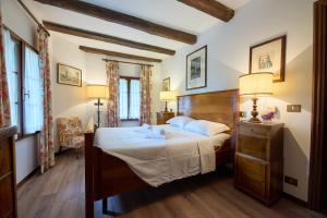 a bedroom with a large bed with a wooden headboard at Hotel Conti Formentini in San Floriano del Cóllio