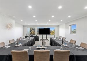 a conference room with tables and chairs and a flat screen tv at Park Proxi Gibraltar Bowral in Bowral