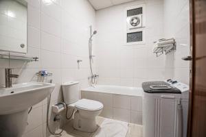a white bathroom with a toilet and a sink at فندق غالية احد in Al Madinah