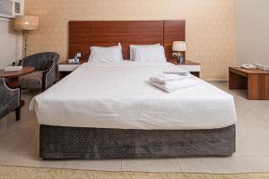a bedroom with a large bed with a wooden headboard at فندق غالية احد in Al Madinah