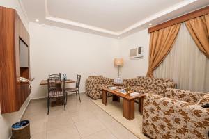 a living room with a couch and a table at فندق غالية احد in Al Madinah