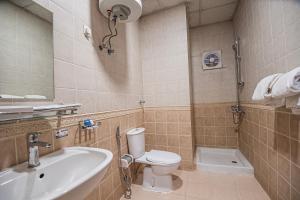 a bathroom with a toilet and a sink at فندق غالية احد in Al Madinah