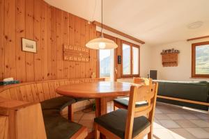 a dining room with a wooden table and chairs at Sillur 2 - Apartment in Innerarosa in Arosa