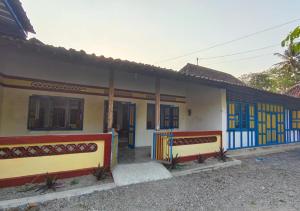 una casa con puertas azules y amarillas en Sendangarum Village Guest House Jogja, 