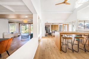 a kitchen and living room with white walls and wood floors at 'Poolside Haven' Your Mount Eliza Family Getaway in Melbourne