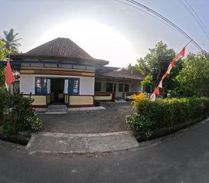 una casa con banderas delante de ella en Sendangarum Village Guest House Jogja, 