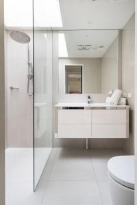 a white bathroom with a shower and a sink at 'Poolside Haven' Your Mount Eliza Family Getaway in Melbourne
