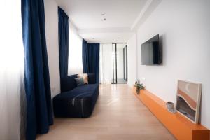 een woonkamer met een bank en een tv bij Ukiyo Hotel in Petaling Jaya