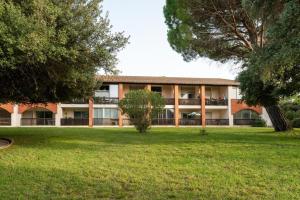 een gebouw met een groen park ervoor bij Studio Camargue in Nîmes