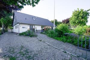 a house with a cobblestone driveway in front of it at Super-Cottage Nordstrand in Nordstrand