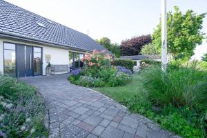 a walkway in front of a house with flowers at Super-Cottage Nordstrand in Nordstrand