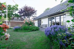 a garden with purple flowers in front of a house at Super-Cottage Nordstrand in Nordstrand