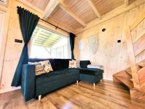 salon z niebieską kanapą i oknem w obiekcie Domki Lawendowy Zakątek w Boszkowie