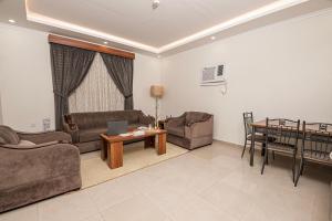 a living room with a couch and a table at فندق غالية احد in Al Madinah