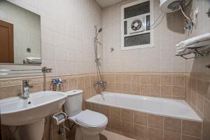 a bathroom with a tub and a toilet and a sink at فندق غالية احد in Al Madinah