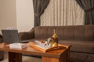 a living room with a couch and a coffee table with a laptop at فندق غالية احد in Al Madinah