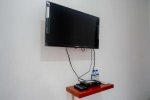 a flat screen tv hanging on a wall at RedDoorz near Alun Alun Wonosobo 2 in Wonosobo