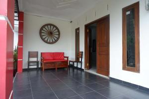 a room with a table and chairs and a clock on the wall at RedDoorz near Alun Alun Wonosobo 2 in Wonosobo