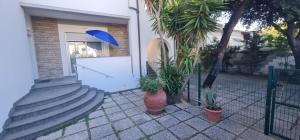 een huis met een witte deur en een blauwe paraplu bij Lecci al Mare in San Vincenzo