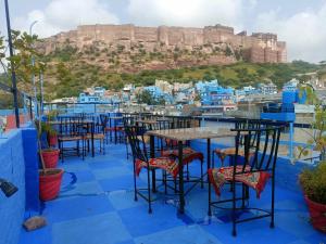 Gopal Home Stay & Guest House في جودبور: اطلالة على المدينة الزرقاء شيفوشون مع الطاولات والكراسي